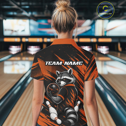 A woman viewed from behind wearing a short-sleeve bowling-themed polo shirt with a raccoon graphic and 'TEAM NAME' text on the back, standing in a bowling alley.