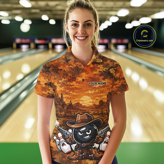 A woman stands in a bowling alley wearing a short-sleeve button-up shirt with a western sunset landscape print and a bowling-themed cartoon character on the front. The shirt has a placeholder text 'YOUR NAME' on the chest.