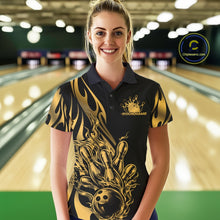 Load image into Gallery viewer, Female model front view at a bowling lane wearing a black polo shirt showcasing a golden metal tribal flame bowling ball striking pins in a powerful action scene.