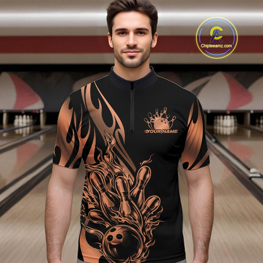 Male model seen front view in a bowling lane wearing a black quarter zip shirt featuring rose gold gradient tribal flame with bowling ball striking pins design.