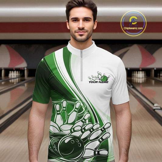 Male model in a bowling alley wearing a white and green quarter zip shirt with a dynamic curved graphic of a bowling ball hitting pins.