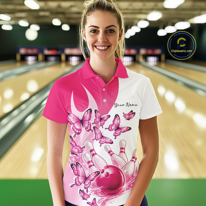 Female model wearing a white and pink bowling polo shirt with butterfly accents and bowling graphics at the bowling lane.