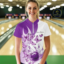 Load image into Gallery viewer, Female model in a white and purple bowling quarter zip featuring butterfly artwork and bowling graphics, front view inside a bowling center