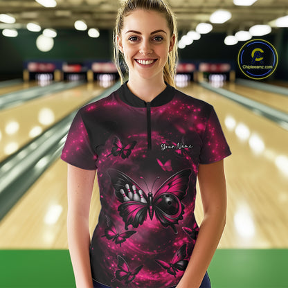 Female model at a bowling lane wearing a quarter-zip bowling shirt with a pink and black butterfly artwork incorporating a bowling ball body.