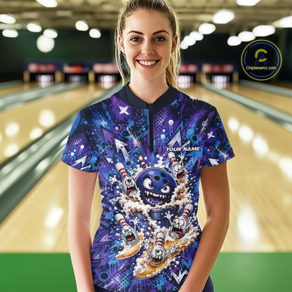 Front view of a female model in a bowling lane wearing a blue and purple bowling quarter-zip shirt featuring a blue monster bowling ball leading monster bowling pins holding overflowing beer mugs with colorful graffiti-style splatter graphics.