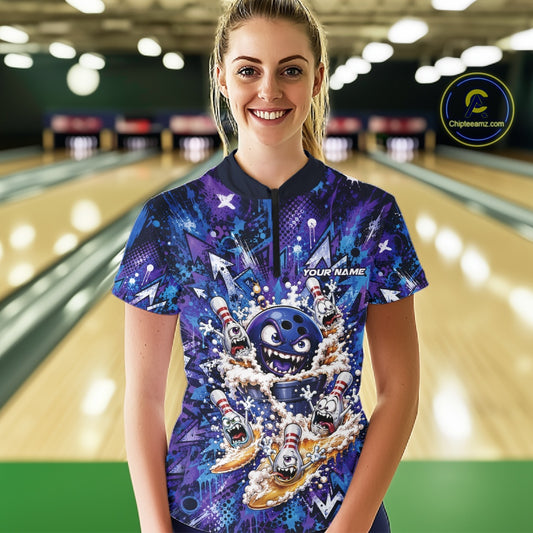 Front view of a female model in a bowling lane wearing a blue and purple bowling quarter-zip shirt featuring a blue monster bowling ball leading monster bowling pins holding overflowing beer mugs with colorful graffiti-style splatter graphics.