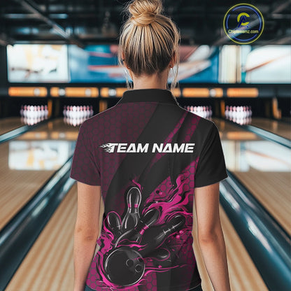 Back view of a female model in a bowling center wearing a black and pink polo shirt featuring a fiery bowling action scene.