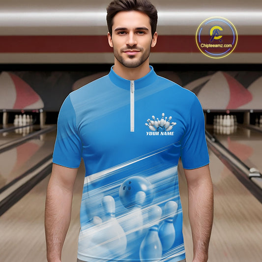 Front view male model at the bowling lane wearing a blue quarter zip shirt with bowling ball and pins over a pink geometric pattern.