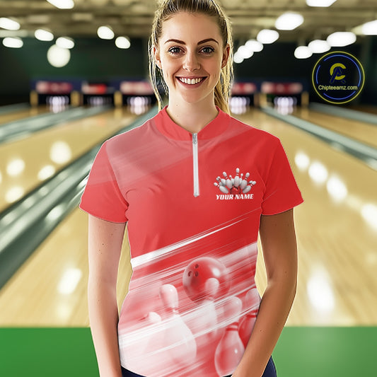 Front view female model in a bowling lane wearing a red quarter zip shirt with bowling ball and pins geometric artwork.