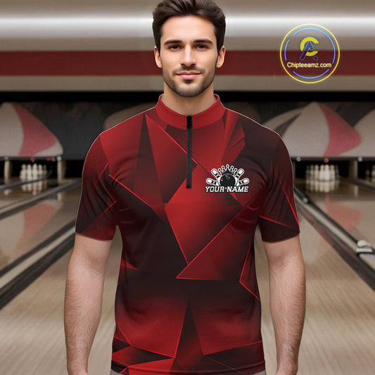 Man wearing a red and black bowling shirt with a logo in a bowling alley.
