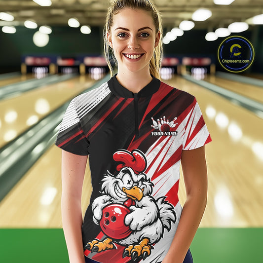 A woman stands in a bowling alley wearing a short-sleeve bowling shirt with a bold red, black, and white graphic design featuring a cartoon chicken holding a bowling ball. The shirt has diagonal stripes and a small white crown graphic with placeholder text.