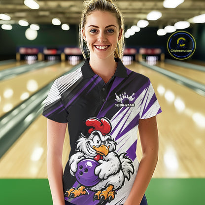 A woman stands in a bowling alley wearing a custom printed bowling shirt. The shirt features a black and purple design with a cartoon rooster holding a purple bowling ball, and white diagonal stripes.