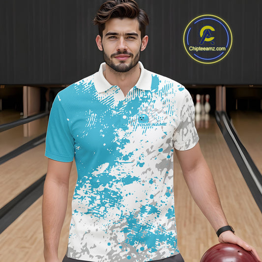 Front view of a male model in a bowling lane wearing a teal blue and white splatter polo shirt with dynamic sporty bowling visuals.