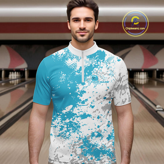 Male model in a bowling lane wearing teal blue and white quarter zip shirt, front view showcasing splatter pattern with modern athletic styling