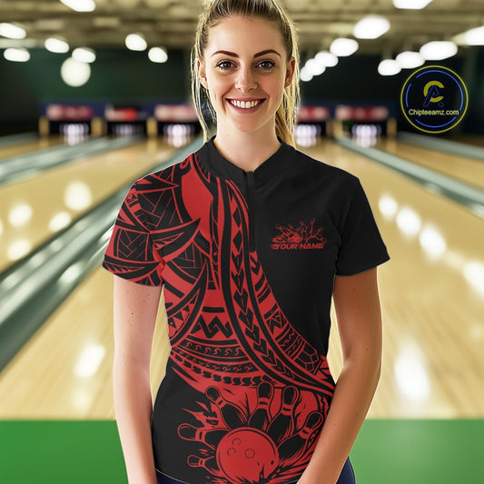Woman wearing a black and red bowling shirt with a logo in a bowling alley.