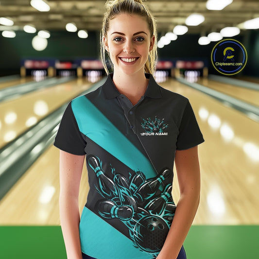 Female model front view at bowling lane wearing black and turquoise blue polo shirt with flaming bowling ball hitting pins in dynamic sports scene.