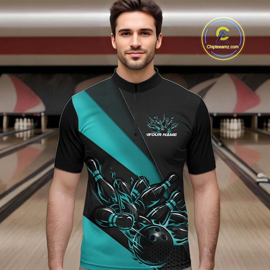 Male model seen from the front in a bowling lane wearing a black and turquoise quarter zip shirt featuring a flaming bowling ball striking pins in a dynamic action scene.