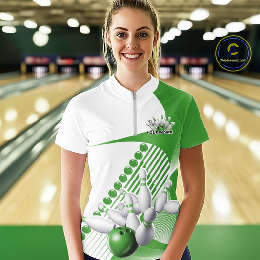 Female model at the bowling lane wearing a white and green bowling quarter zip with asymmetric wavy stripes and dynamic bowling strike artwork.
