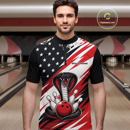 A man stands in a bowling alley wearing a black, white, and red bowling shirt with stars, diagonal stripes, a cobra, pins, and an red ball.
