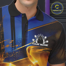 Load image into Gallery viewer, Close-up of the left chest on a bowling polo shirt featuring a glossy blue bowling ball and pins wrapped in flowing metallic gold ribbons.