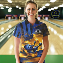 Load image into Gallery viewer, Front view of a female model wearing a bowling polo shirt with a glossy blue bowling ball and pins wrapped in elegant flowing gold ribbons at a bowling lane.