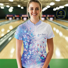 Load image into Gallery viewer, Female model wearing a bowling quarter zip with pastel purple and pink holographic butterflies and bowling artwork, front view at the bowling lane