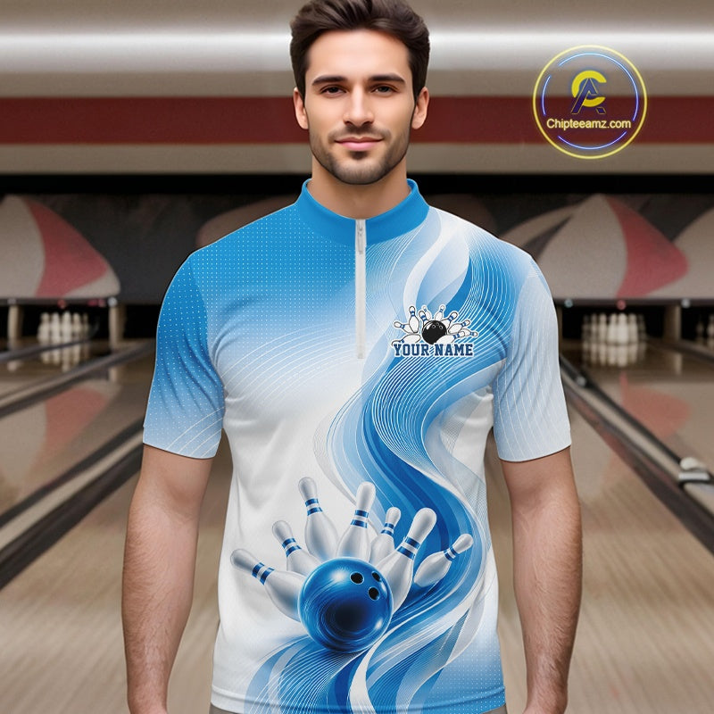 Front view of a male model in a white and blue bowling quarter zip with flowing abstract wave graphics and a glossy bowling ball striking pins