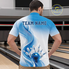 Load image into Gallery viewer, Male model in a white and blue bowling quarter zip showcasing flowing abstract wave accents and a glossy bowling ball striking pins, front view in a bowling alley