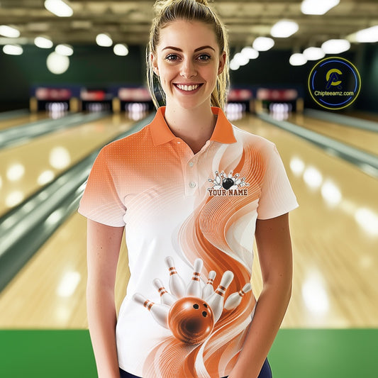 Front view of a womens white and orange bowling polo shirt featuring flowing wave graphics and a dynamic bowling action scene