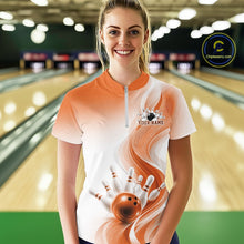 Load image into Gallery viewer, Front view of a female model in a white and orange bowling quarter zip featuring flowing wave graphics and a glossy bowling ball knocking down pins
