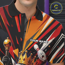 Load image into Gallery viewer, Close-up of the left chest on a black, red, and orange bowling polo shirt featuring a crowned cartoon bowling ball holding a royal scepter with animated bowling pins and colorful burst artwork.