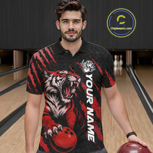 Load image into Gallery viewer, Front view of a male model in a bowling lane wearing a black and red bowling polo shirt featuring a roaring tiger holding a red bowling ball with red claw-stripe graphics and a geometric background pattern.