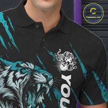 Load image into Gallery viewer, Close-up view of the left chest on a black and teal blue bowling polo shirt showcasing a roaring tiger holding a teal blue bowling ball with teal blue claw-stripe artwork and a geometric background pattern.