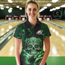 Load image into Gallery viewer, Female model wearing a black and green bowling polo shirt at a bowling lane featuring sugar skull artwork and bowling pins design.