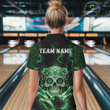 Load image into Gallery viewer, Back view of a female model in a bowling alley wearing a black and green polo with floral sugar skull and bowling ball graphics.