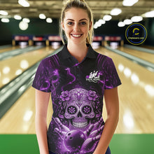 Load image into Gallery viewer, Female model at a bowling lane wearing a black and purple polo shirt with floral sugar skull artwork and bowling-themed graphics.