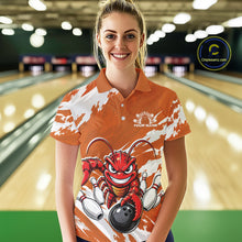 Load image into Gallery viewer, Front view of a female model in a bowling alley wearing an orange custom bowling polo shirt with a fierce yet funny crawfish bowling character and a distressed background design.