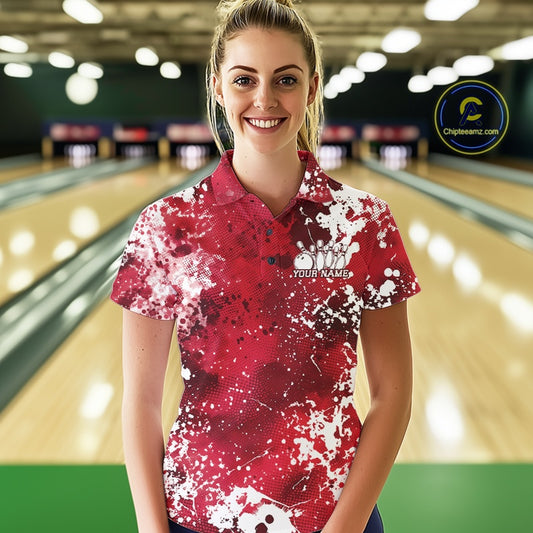 Woman wearing a red and white bowling shirt with a logo in a bowling alley.