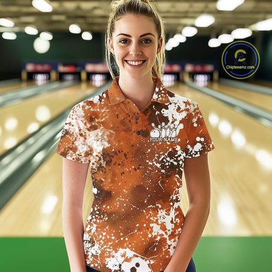 Front view of a male model in a bowling alley wearing a bowling quarter-zip shirt featuring a white paint splatter design on a pink shirt.
