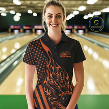Load image into Gallery viewer, Female model at a bowling lane wearing a black bowling polo shirt with orange flame bowling strike artwork and patriotic graphics.