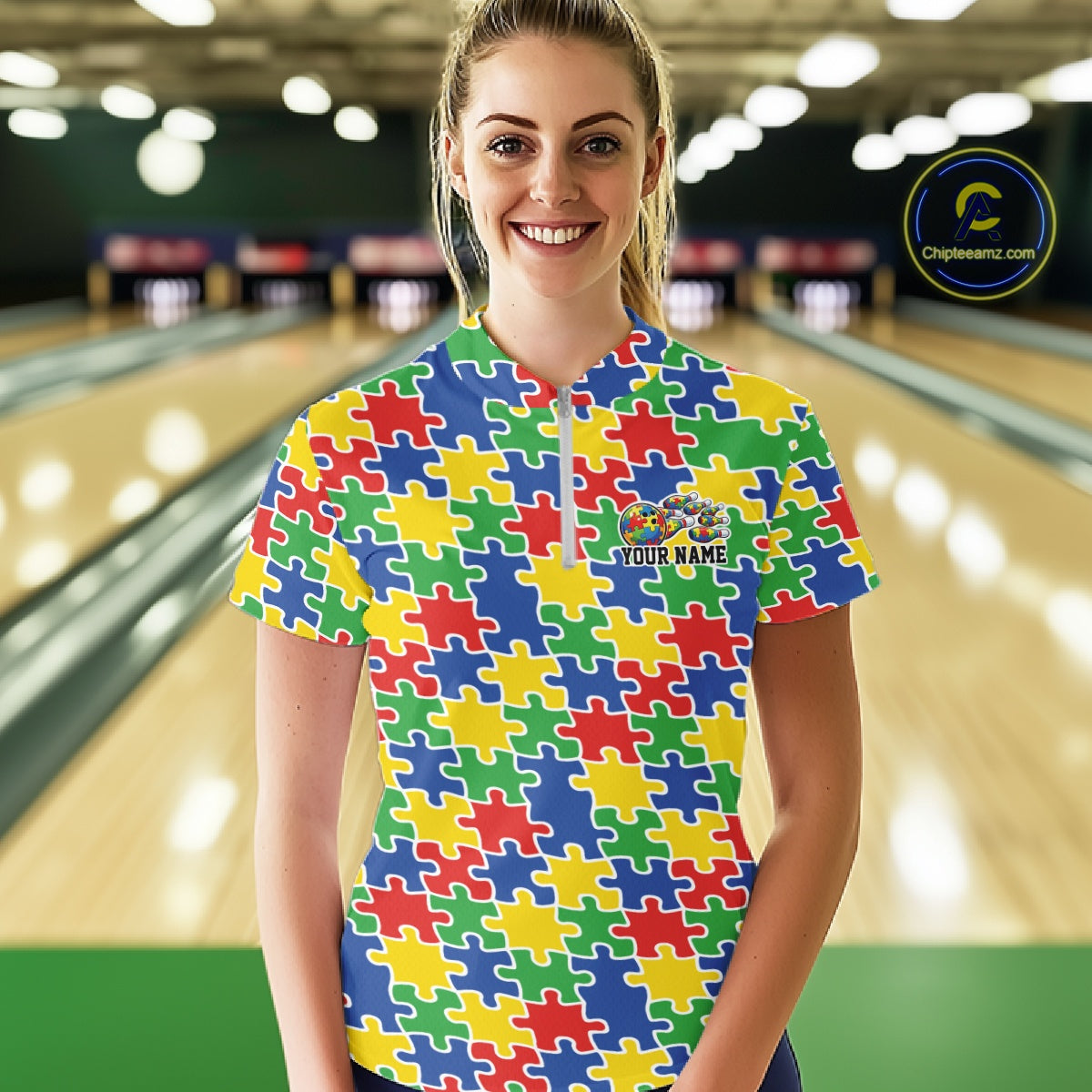 Female model in a bowling lane wearing a multicolored quarter-zip shirt, seamless puzzle pattern design in bright red, blue, green, and yellow tones.
