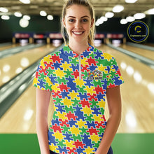 Load image into Gallery viewer, Female model in a bowling lane wearing a multicolored quarter-zip shirt, seamless puzzle pattern design in bright red, blue, green, and yellow tones.