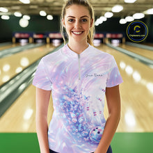 Load image into Gallery viewer, Female model wearing a bowling quarter zip with pastel holographic butterfly artwork and bowling graphics, front view inside a bowling alley
