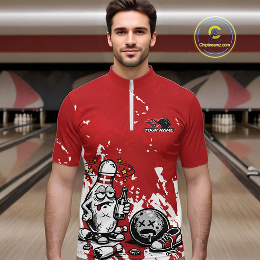 Male model in a bowling lane wearing a red and white quarter-zip shirt, humorous splatter bowling pin artwork holding beer bottle and bowling ball.