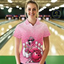Load image into Gallery viewer, Female model at a bowling lane wearing a pink bowling polo shirt with a crowned flamingo holding a cocktail and resting against a bowling ball.