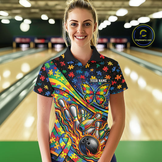 Female model in a bowling alley wearing a colorful polo shirt, front view highlighting autism ribbon and butterfly flame bowling artwork