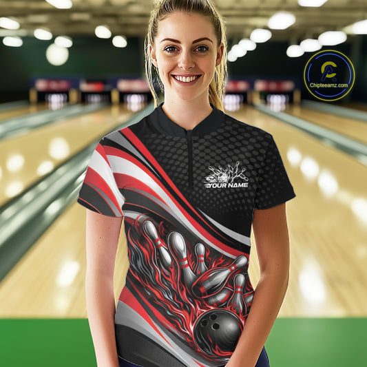 Female model wearing a black and red quarter-zip bowling shirt in a bowling lane, flame bowling ball and pins artwork creating dynamic strike action.