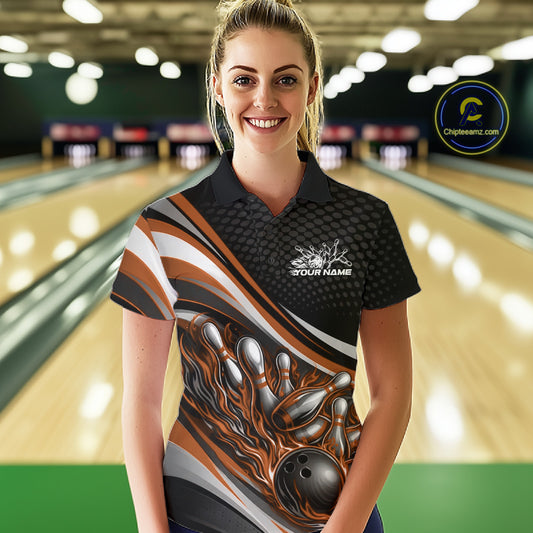 Female model at a bowling lane wearing a black and orange polo shirt, fiery bowling strike scene with dynamic pin explosion effect.