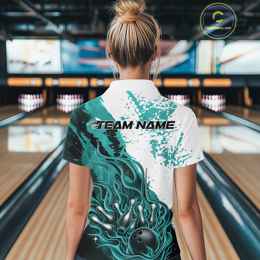 Back view of a female model in a bowling lane wearing a black quarter-zip shirt featuring turquoise blue and white flame bowling ball and pins artwork with athletic bowling styling.