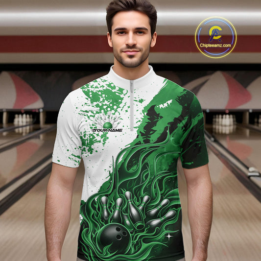 Front view of a male model in a bowling lane wearing a black quarter-zip shirt with black, green and white flame bowling ball and pins graphics.